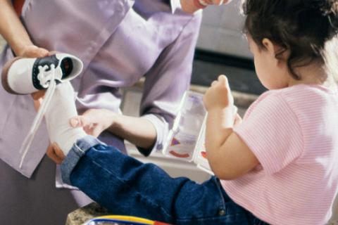 Mom helping daughter put on shoes