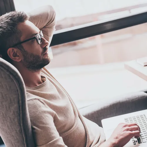 Parent thinking while communicating with co-parent on laptop
