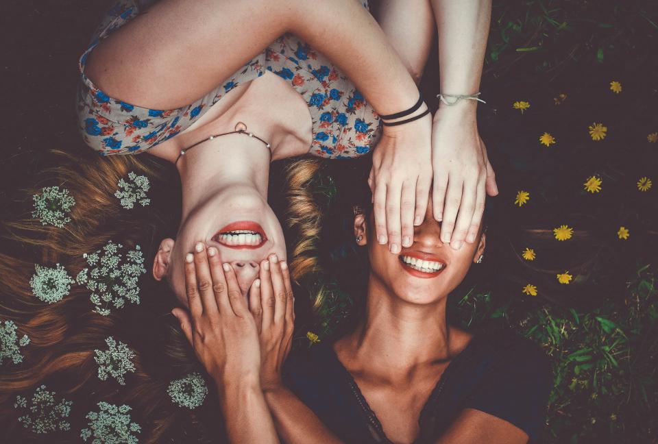 Sisters covering each other's eyes while smiling