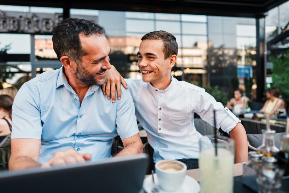 Dad and teenage son eating at a restaurant.